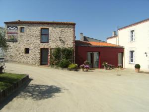 a large stone building with a red and white building at Domaine du Fief aux Dames in Monnières