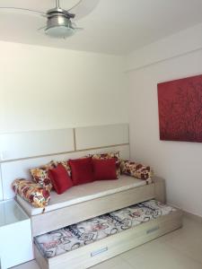 a couch with red pillows in a room at Apartamento Capitães de Areia in Ilhéus