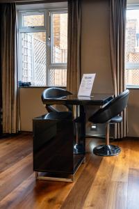 1 mesa y 2 sillas en una habitación con ventana en Luxury Studio Flat Victoria SW1 en Londres