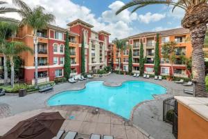 an apartment complex with a swimming pool and palm trees at Two bedroom 2 bath close to Disneyland CA in Anaheim