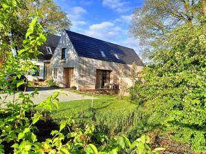 una antigua casa de piedra con techo negro en Den Broecke, en Bornerbroek