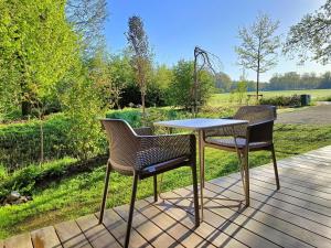 2 sillas y una mesa en el patio en Den Broecke, en Bornerbroek