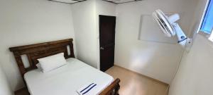 a small bedroom with a bed and a fan at APARTAHOTEL HEFZIBA in Barranquilla