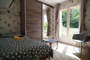 La Milesse的住宿－Maison des bois - La pause des 24 heures du Mans，卧室配有床、椅子和窗户。