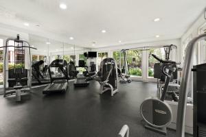 a gym with several treadmills and elliptical machines at Arpita Beach Resort in Chandīpur