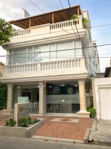 a large white building with a balcony on a street at Hotel San Miguel Imperial in Santa Marta