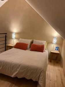 ein Schlafzimmer mit einem Bett mit zwei Lampen an zwei Tischen in der Unterkunft Le 6 