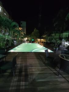 a large swimming pool at night with two chairs at Arpita Beach Resort in Chandīpur
