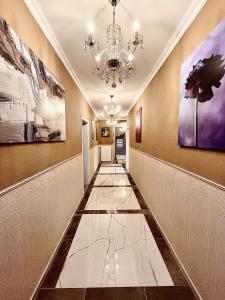 a hallway with a chandelier and paintings on the walls at Lot54 Deluxe Apartements in Neidenbach
