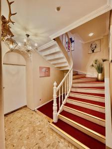 a staircase in a home with a chandelier at Lot54 Deluxe Apartements in Neidenbach