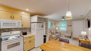 a kitchen with white appliances and a dining room at BEACHY SISTERS A Duplex in Jekyll Island