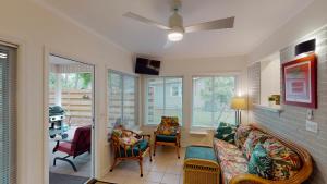 a living room with a couch and chairs and windows at BEACHY SISTERS A Duplex in Jekyll Island