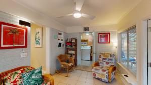 a living room with a couch and chairs and a refrigerator at BEACHY SISTERS A Duplex in Jekyll Island
