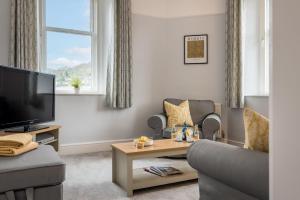 een woonkamer met een bank en een tv bij Wansfell Heights in Ambleside