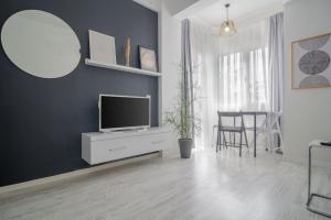 een woonkamer met een televisie op een witte kast bij Alex Suites Lara in Antalya