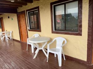 een tafel en stoelen op de veranda van een gebouw bij Hostal Inn II Rionegro in Rionegro