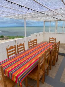 stół z krzesłami i kolorową tkaniną o paskach w obiekcie Villa do Mar Calheta w mieście Calheta