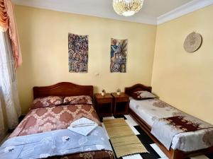 1 dormitorio con 2 camas y lámpara de araña en soleado apartamento al lado de la preciosa medina , a 3 minutos de la playa andando II, en Asilah