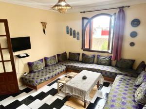 sala de estar con sofá y mesa en soleado apartamento al lado de la preciosa medina , a 3 minutos de la playa andando II, en Asilah