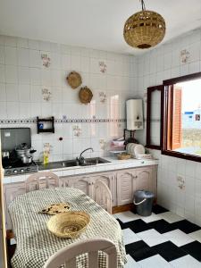 cocina con mesa y fregadero en soleado apartamento al lado de la preciosa medina , a 3 minutos de la playa andando II en Asilah