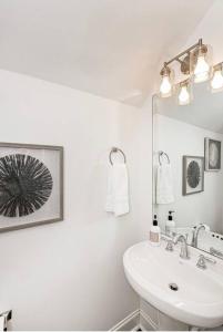 a white bathroom with a sink and a mirror at NEW 3 BD/2.5BA Townhouse by LSU in Baton Rouge