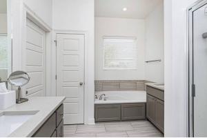 a white bathroom with a tub and a sink at NEW 3 BD/2.5BA Townhouse by LSU in Baton Rouge