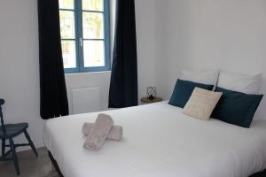 a bedroom with a large white bed with towels on it at La terrasse du JULES in Romans-sur-Isère