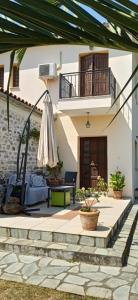 un patio con una sombrilla y una casa en villa Rodo, en Platanidia