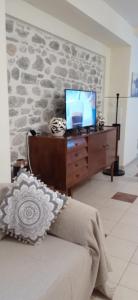 sala de estar con sofá y TV en un escritorio en villa Rodo, en Platanidia