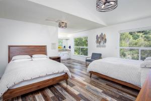 a white bedroom with a large bed and a chair at Sierra River House 5 min to Sequoia Park Entrance in Three Rivers