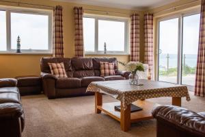 a living room with a couch and a table at Rooftops - Sea Views Near Village and Beach in Saundersfoot