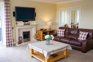 a living room with a couch and a fireplace at Rooftops - Sea Views Near Village and Beach in Saundersfoot