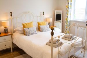 a bedroom with a white bed with pillows at Rooftops - Sea Views Near Village and Beach in Saundersfoot