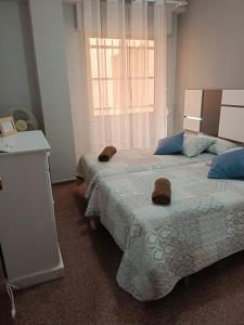 1 dormitorio con 2 camas con sombreros en Apartamento piscina Santa Pola, en Santa Pola