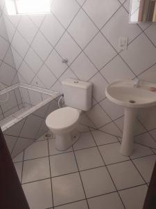Baño blanco con aseo y lavamanos en Hospedagem em apto em Rolante, en Rolante