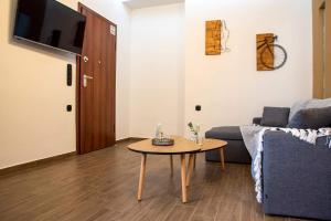 a living room with a table and a couch at Polytelia Apartment Karystos in Karistos