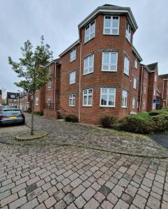 um edifício de tijolos com uma árvore em frente em Impeccable 2-Bed Apartment in Newcastle upon Tyne em Newcastle upon Tyne