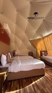 a bedroom with two beds in a tent at Nasa desert luxury camp in Wadi Rum +49 photos