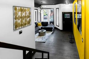 een woonkamer met een bank, een tafel en een gele deur bij The Black And White Suite in Chicago