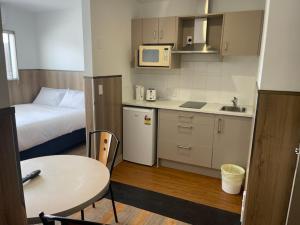 a small kitchen with a bed and a small table at Conway Motel Manukau in Auckland