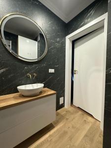 a bathroom with a sink and a mirror on the wall at Celine Apartments in Lębork +23 photos