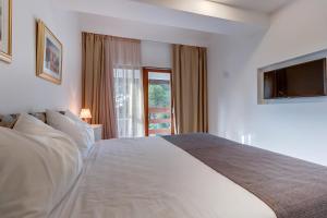 1 dormitorio con 1 cama blanca y TV en Villa Lavanda - Kandija en Čunski