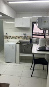 a kitchen with white cabinets and a desk with a computer at 52 LOFT quadruplo · LOFT perto da São Paulo EXPO edo metrô Jabaguara in São Paulo