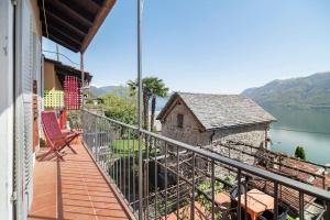 einen Balkon eines Hauses mit Blick auf das Wasser in der Unterkunft Come Relax and Enjoy the Breathtaking Views in Brissago