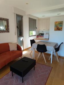 ein Wohnzimmer mit einem Sofa und einem Tisch in der Unterkunft Apartamento Playa Ladeira in Baiona