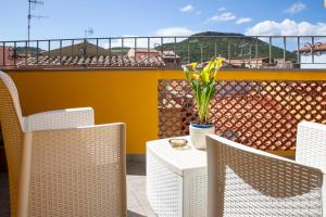 a table and chairs with a vase of flowers on a balcony at La Torre del Pozzo Guest House in Bosa