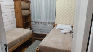 a small room with two beds and a window at Chalé Terra Luni in Urubici