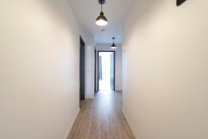 um corredor vazio com paredes brancas e pisos de madeira em Le cosmopolitain em Metz