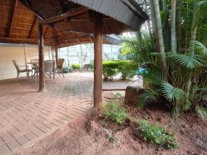 eine Terrasse mit einem Tisch und Stühlen unter einem Pavillon in der Unterkunft B&O's Place in Pretoria