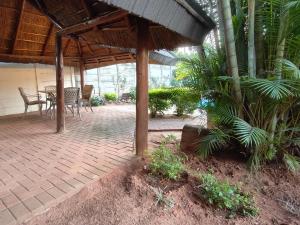 a patio with a table and chairs under a pavilion at B&O's Place in Pretoria